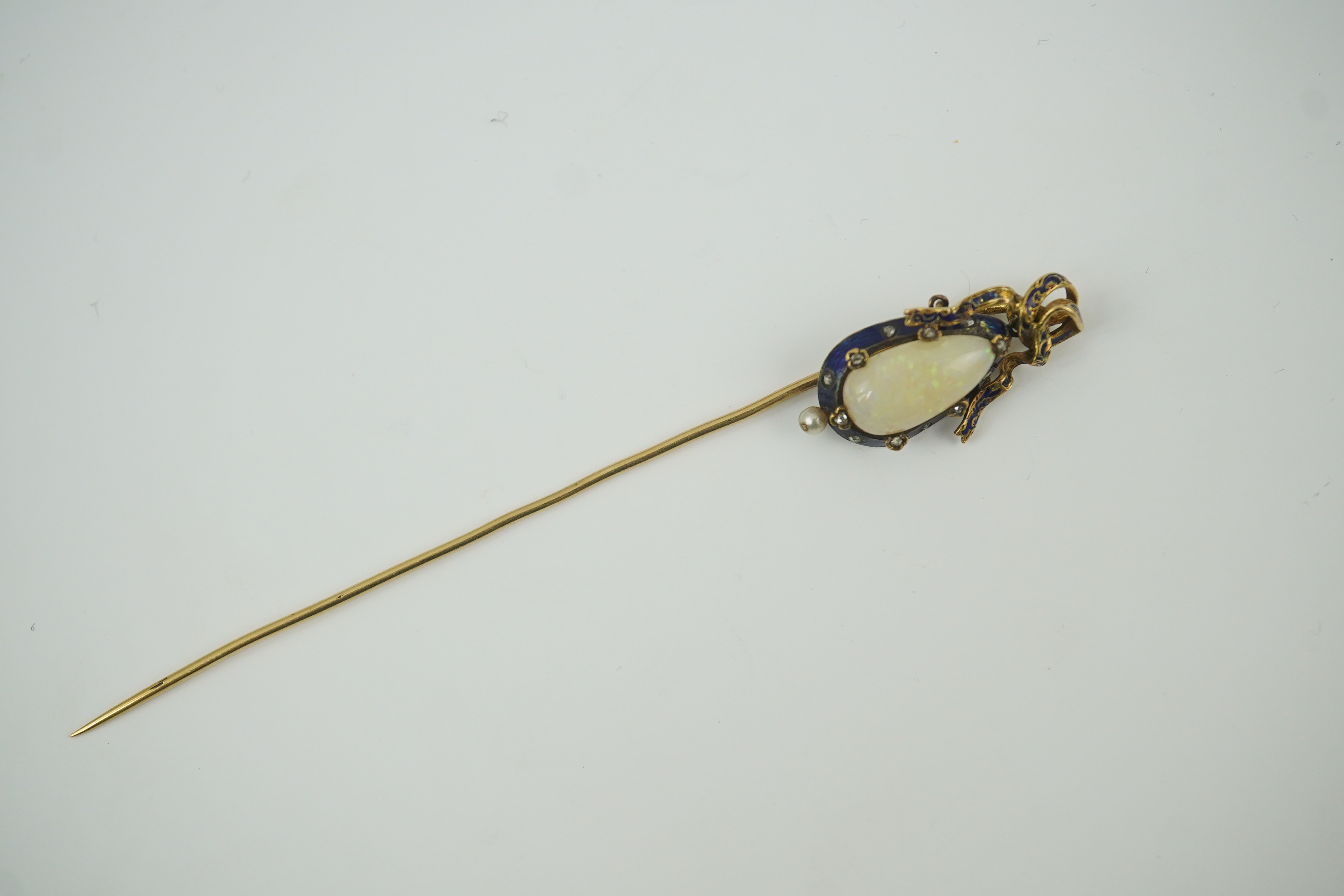 A late Victorian gold, white opal, seed pearl diamond chip and blue enamel set stick pin